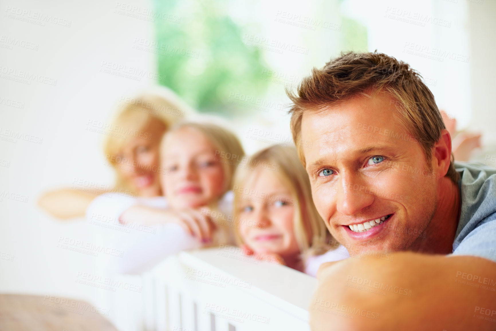 Buy stock photo Portrait, smile and a family lying on a bed together while in their home on a weekend morning. Face, love and a happy father, mother and children in the bedroom of an apartment to relax for bonding