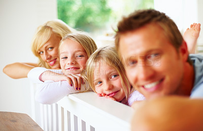 Buy stock photo Portrait, smile and a family lying in a bedroom together while in their home on a weekend morning. Face, love and a happy father, mother and children on the bed of an apartment to relax for bonding