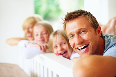 Buy stock photo Portrait, smile and a family laughing on a bed together while in their home on a weekend morning. Face, love and a funny father, mother and kids in the bedroom of an apartment to relax for bonding