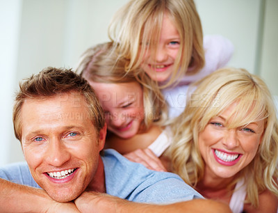 Buy stock photo Portrait, laughing and a family lying on a bed together while in their home on a weekend morning. Face, funny and a happy father, mother and kids in the bedroom of an apartment to relax for bonding