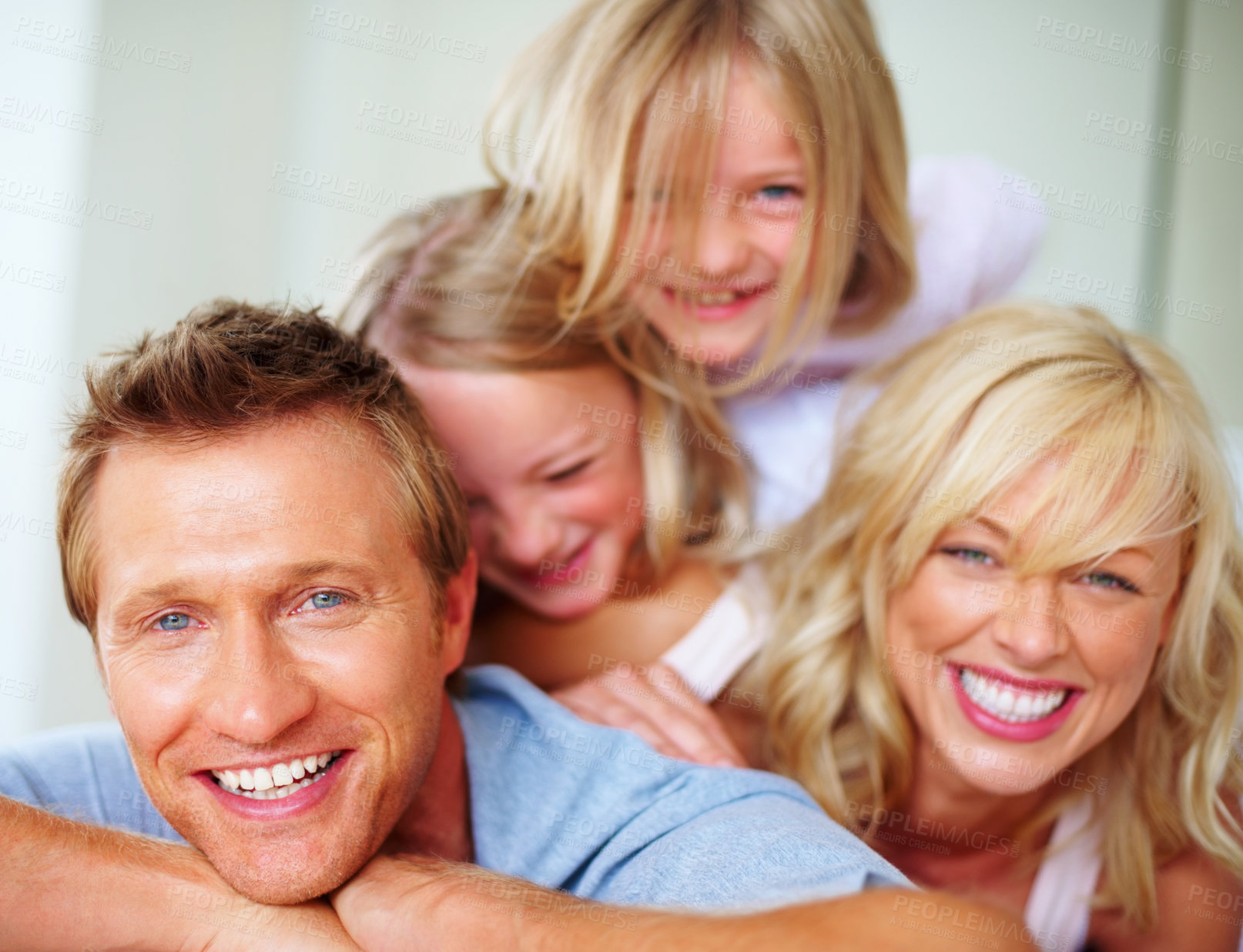 Buy stock photo Portrait, laughing and a family lying on a bed together while in their home on a weekend morning. Face, funny and a happy father, mother and kids in the bedroom of an apartment to relax for bonding