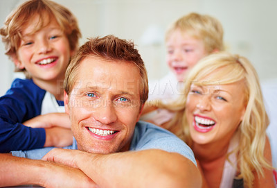 Buy stock photo Portrait, love and laughing with a family on a bed together while in their home on a weekend morning. Face, smile or happy with dad, mom and kids in the bedroom of an apartment to relax for bonding