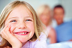 Cheerful young girl with parents in background