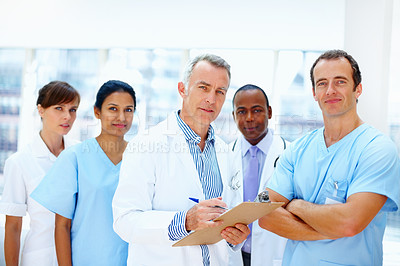 Buy stock photo Doctors, clipboard and team portrait in clinic with staff, senior leader and writing for healthcare. Medic, group and checklist with diversity for men, women and nurses with paperwork in hospital