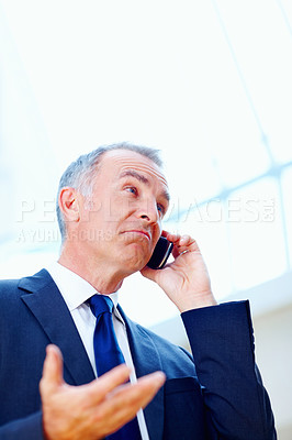 Buy stock photo Senior executive with puzzled look while on cell phone