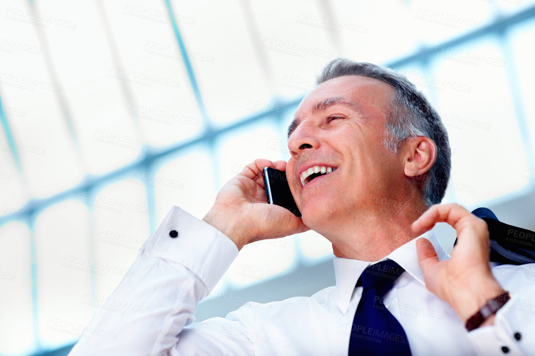 Buy stock photo Executive smiling and looking into distance while talking on cell phone