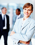 Female executive standing casually with colleagues in background