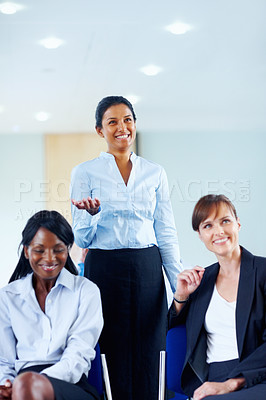 Buy stock photo Businesswoman, smile and excited for presentation at conference, workshop or seminar in boardroom. Diverse group, happy people and listen to speaker, panel or discussion in formal, chic and fashion