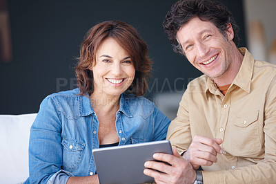 Buy stock photo Shot of a husband and wife using a digital tablet together at home