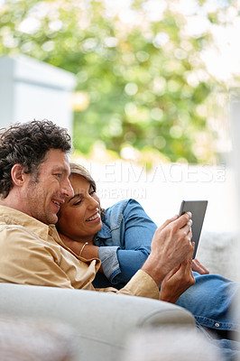 Buy stock photo Shot of a husband and wife using a digital tablet together at home