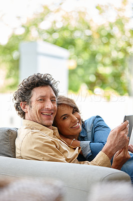 Buy stock photo Shot of a husband and wife using a digital tablet together at home