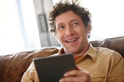 Buy stock photo Shot of a mature man using a digital tablet on the sofa at home