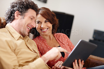 Buy stock photo Shot of a husband and wife using a digital tablet together at home