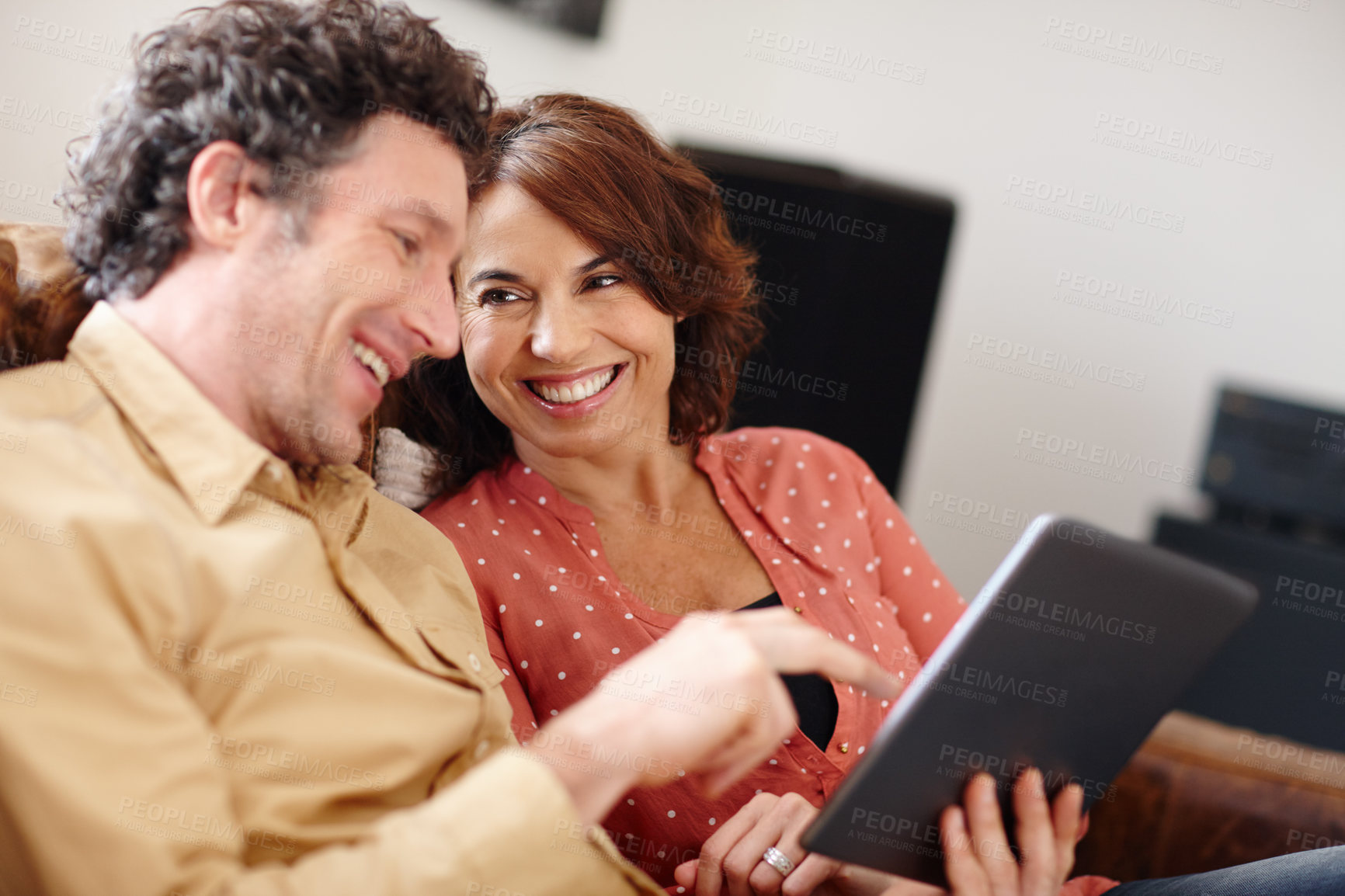 Buy stock photo Shot of a husband and wife using a digital tablet together at home