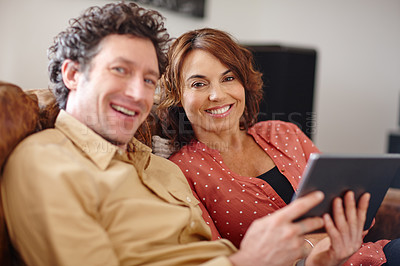 Buy stock photo Shot of a husband and wife using a digital tablet together at home