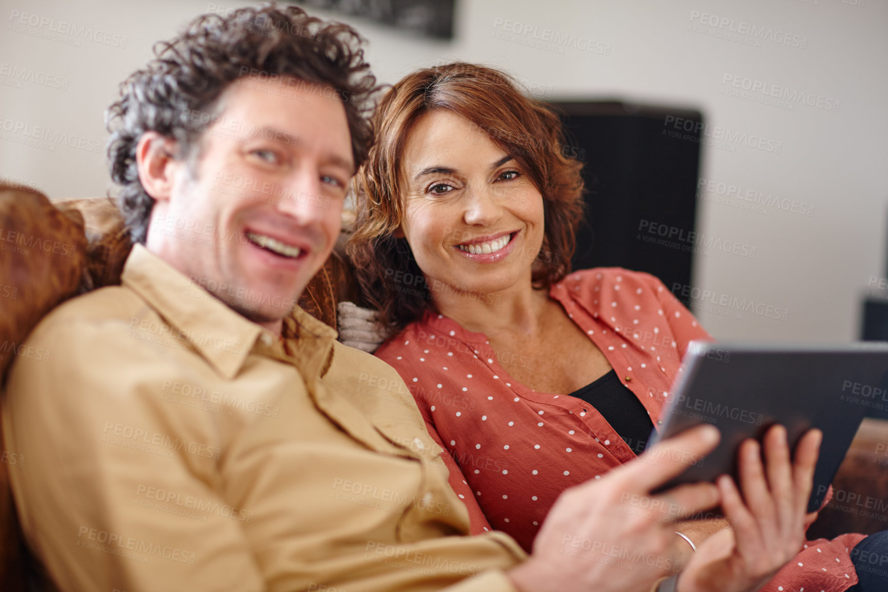 Buy stock photo Shot of a husband and wife using a digital tablet together at home