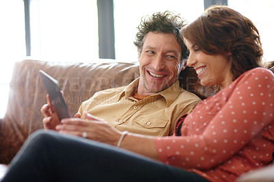 Buy stock photo Shot of a husband and wife using a digital tablet together at home