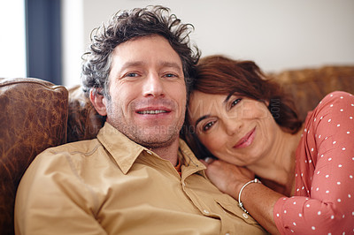 Buy stock photo Shot of a husband and wife relaxing together on the sofa at home