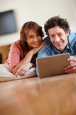 Buy stock photo Shot of a husband and wife using a digital tablet together at home