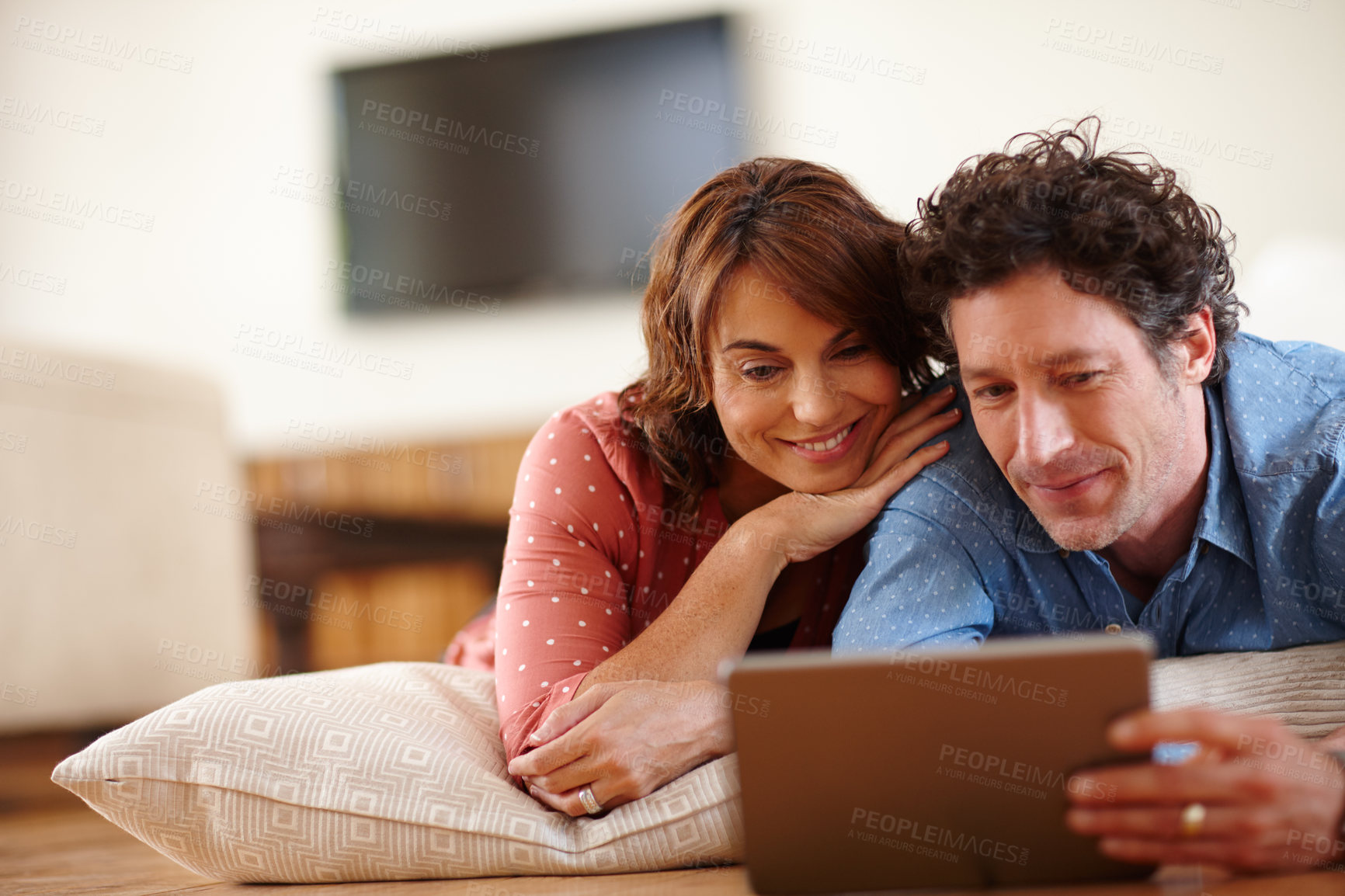 Buy stock photo Shot of a husband and wife using a digital tablet together at home