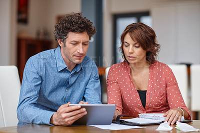 Buy stock photo Shot of a husband and wife doing their budgeting at home