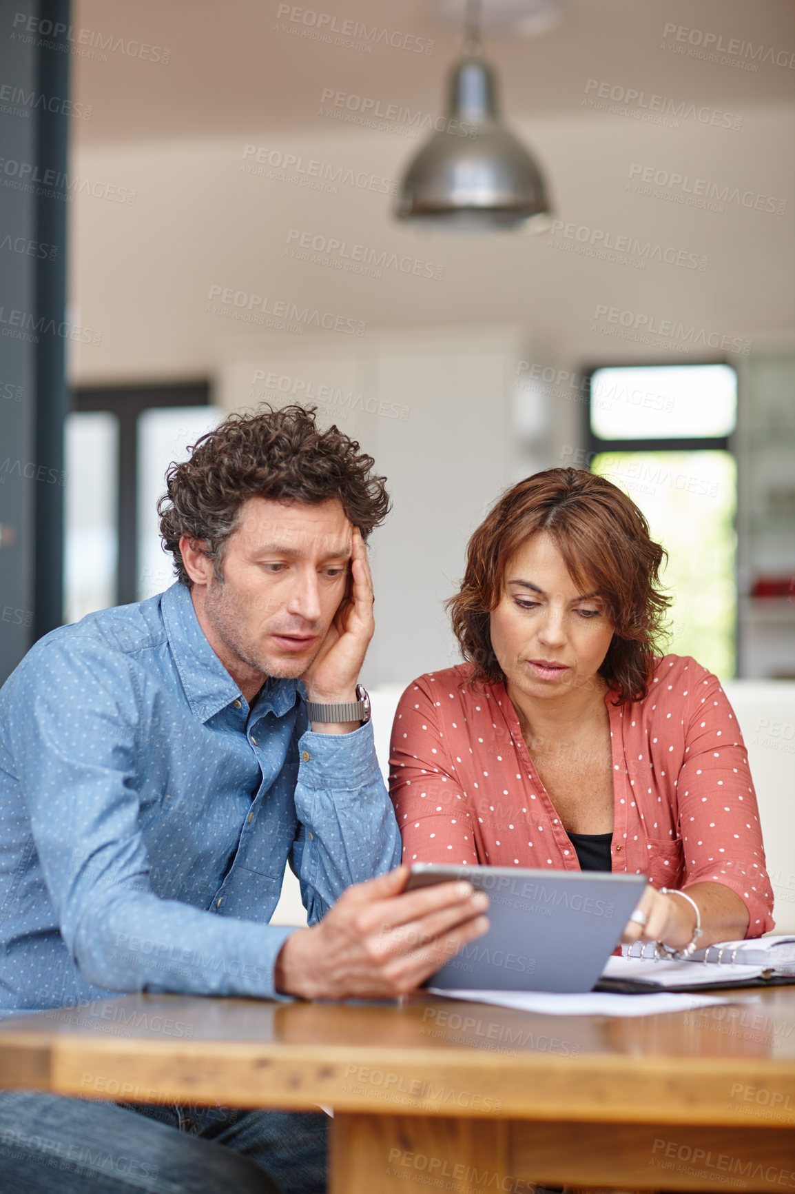 Buy stock photo Shot of a husband and wife doing their budgeting at home