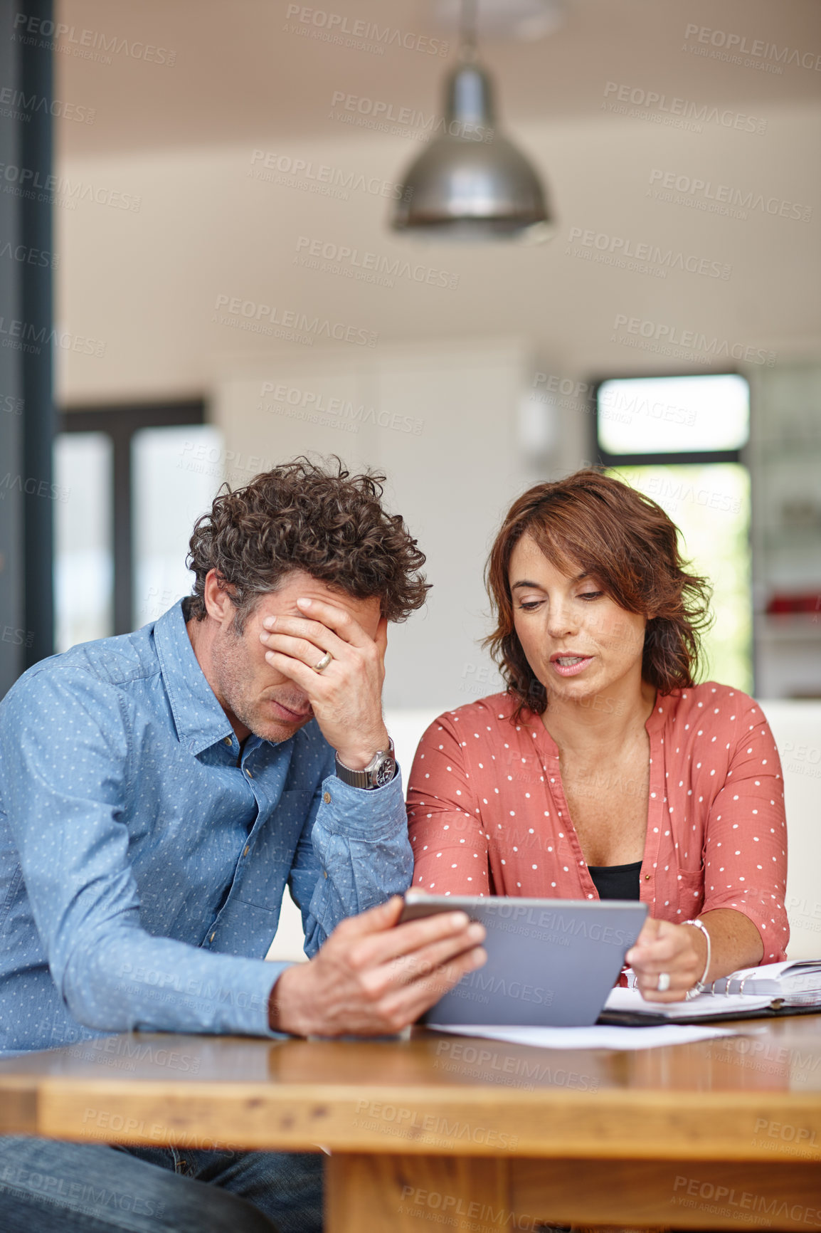 Buy stock photo Shot of a husband and wife doing their budgeting at home