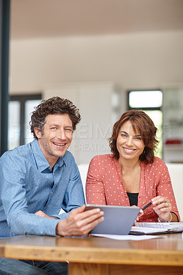 Buy stock photo Shot of a husband and wife doing their budgeting at home