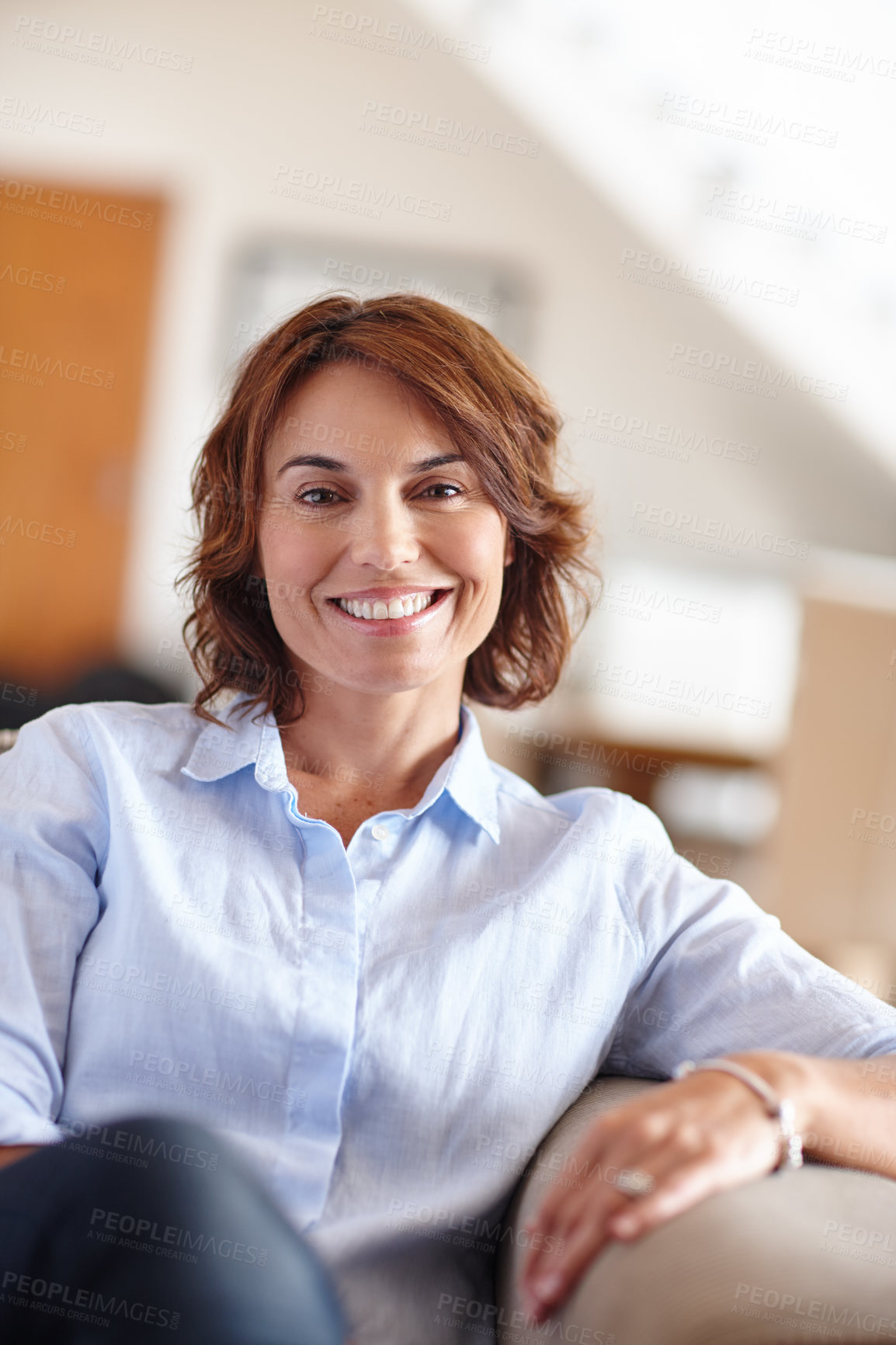 Buy stock photo Portrait of a mature woman sitting on her sofa at home