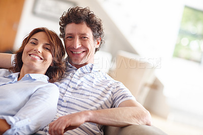 Buy stock photo Shot of a husband and wife relaxing together on the sofa at home