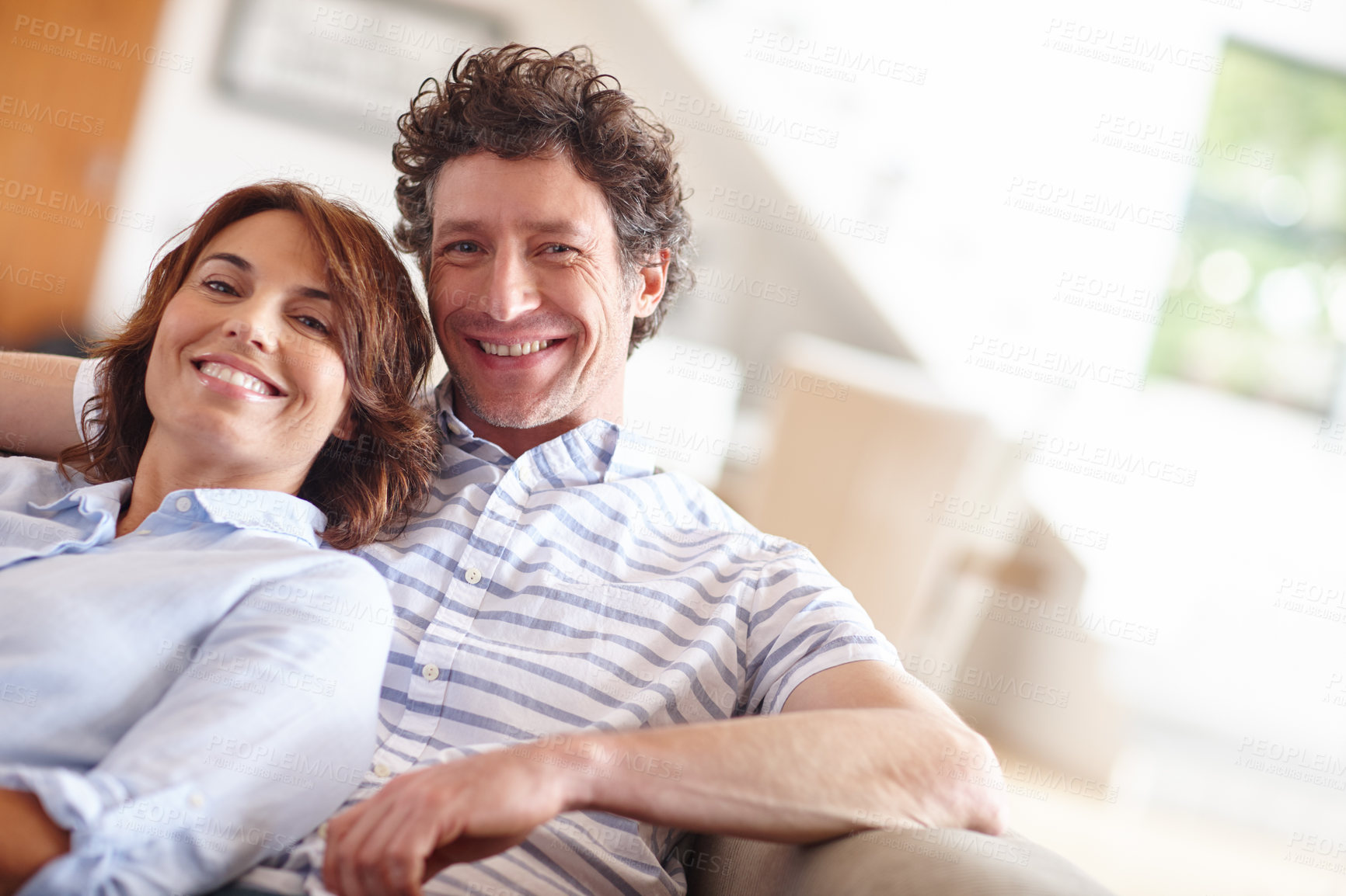 Buy stock photo Shot of a husband and wife relaxing together on the sofa at home