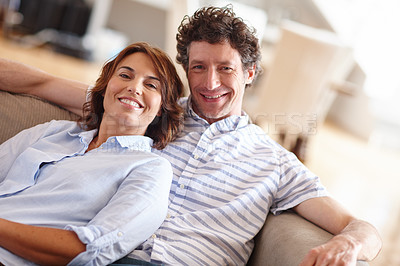 Buy stock photo Shot of a husband and wife relaxing together on the sofa at home