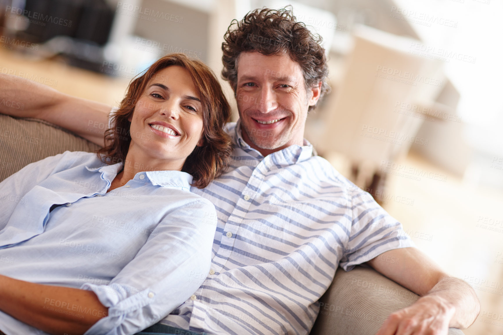 Buy stock photo Shot of a husband and wife relaxing together on the sofa at home