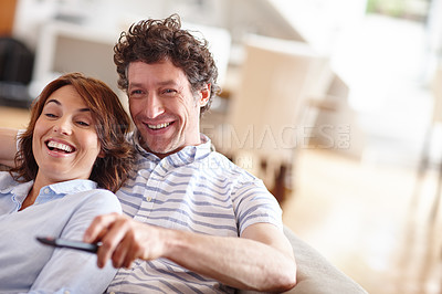 Buy stock photo Shot of a husband and wife watching tv together on the sofa at home