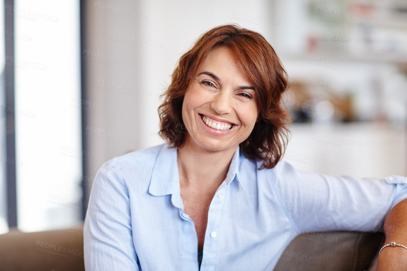 Buy stock photo Portrait of a mature woman sitting on her sofa at home