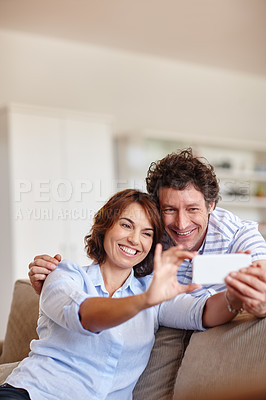 Buy stock photo Cropped shot of a husband and wife taking a selfie together at home