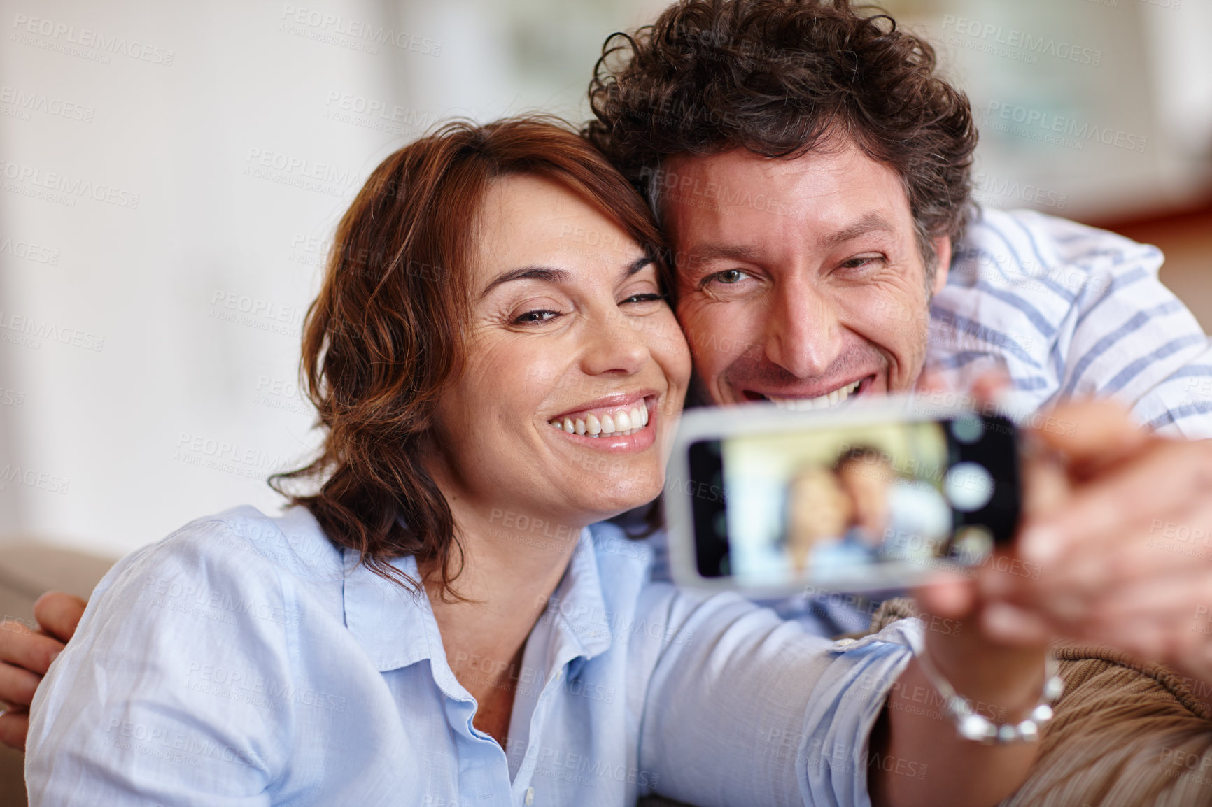 Buy stock photo Cropped shot of a husband and wife taking a selfie together at home