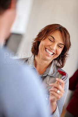 Buy stock photo Shot of a husband giving his wife a flower at home