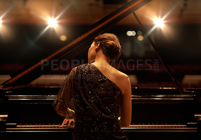 Buy stock photo Shot of a young woman playing the piano during a musical concert