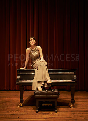 Buy stock photo Shot of a young woman sitting on her piano at the end of a musical concert