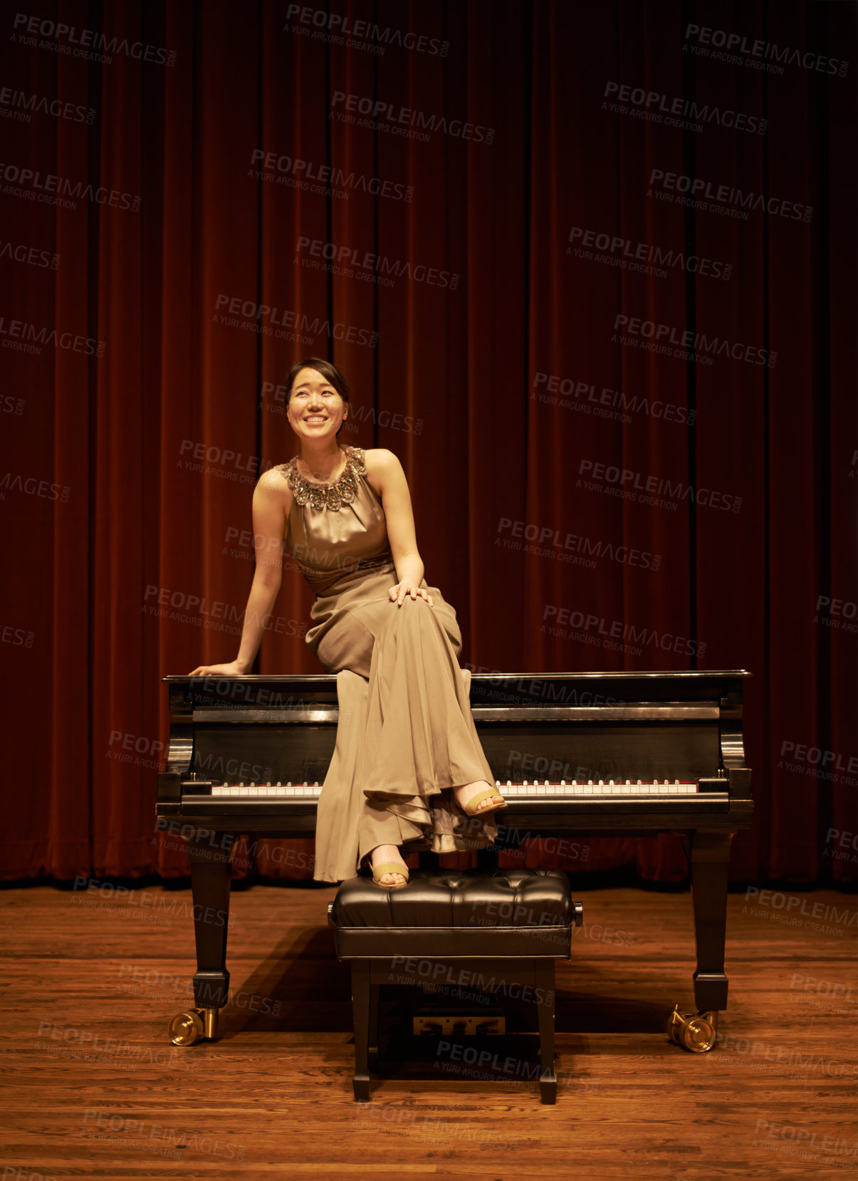 Buy stock photo Shot of a young woman sitting on her piano at the end of a musical concert