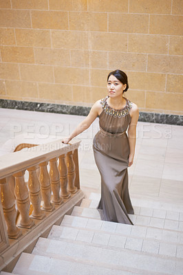 Buy stock photo Woman, dress and elegance for walk on stairs, fashion and classy garment for event. Asian person, steps and satin or luxury and designer outfit, aesthetic and pride for style, confidence and opera