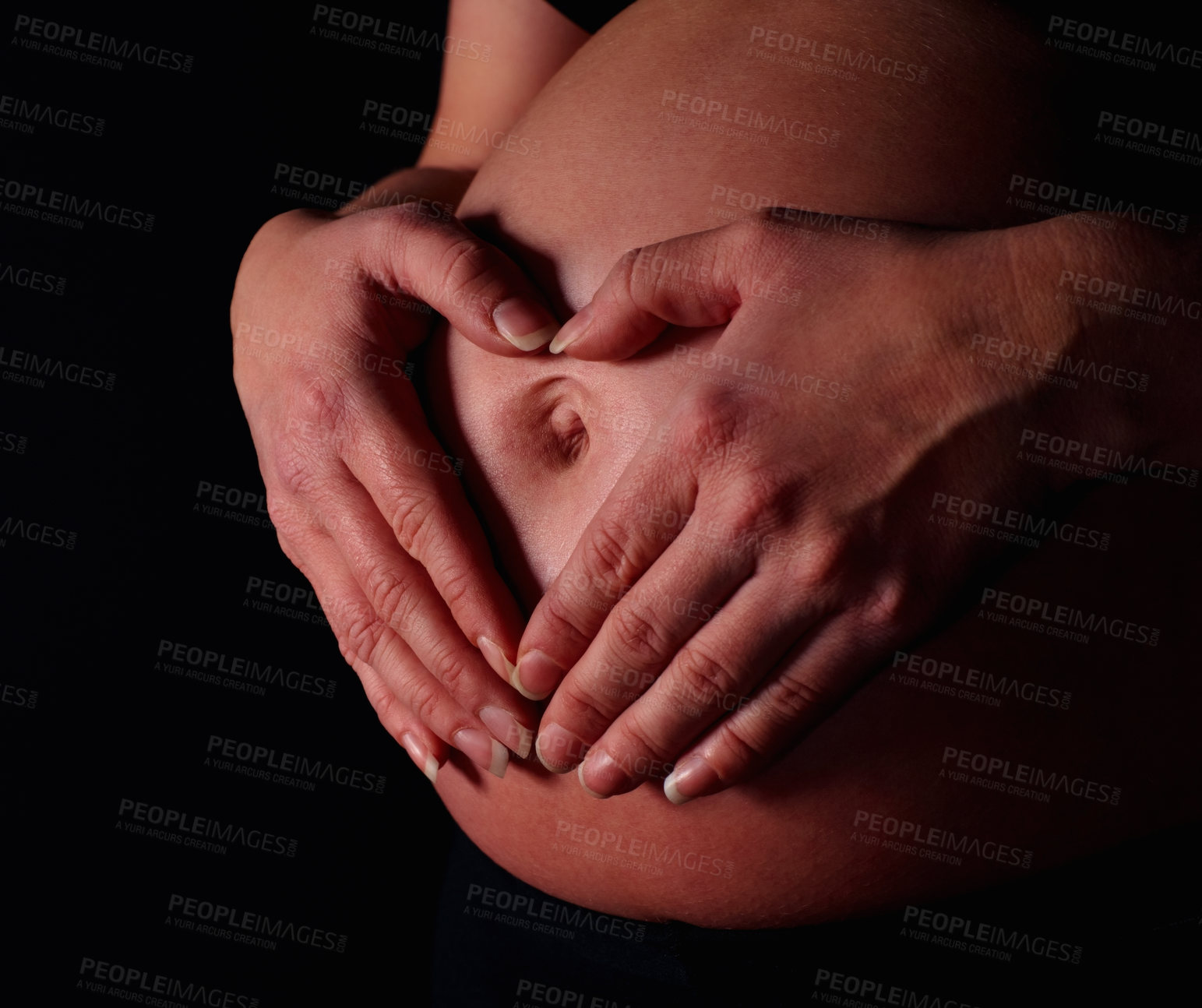 Buy stock photo Detail shot of a pregnant woman making heart shape with hands against black background