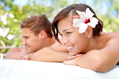 Buy stock photo Massage, relax and happy couple at salon outdoor for skincare, health or wellness on table. Beauty, man and woman at luxury spa with hibiscus flower in nature for therapy on romantic holiday together