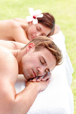 Buy stock photo Massage, calm and couple at spa outdoor for skincare, health or relax for wellness on table. Peace, man and woman at luxury salon with hibiscus flower in nature for natural beauty therapy on holiday