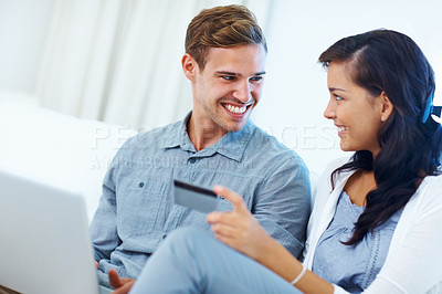 Buy stock photo Young couple at home smiling while shopping online using laptop