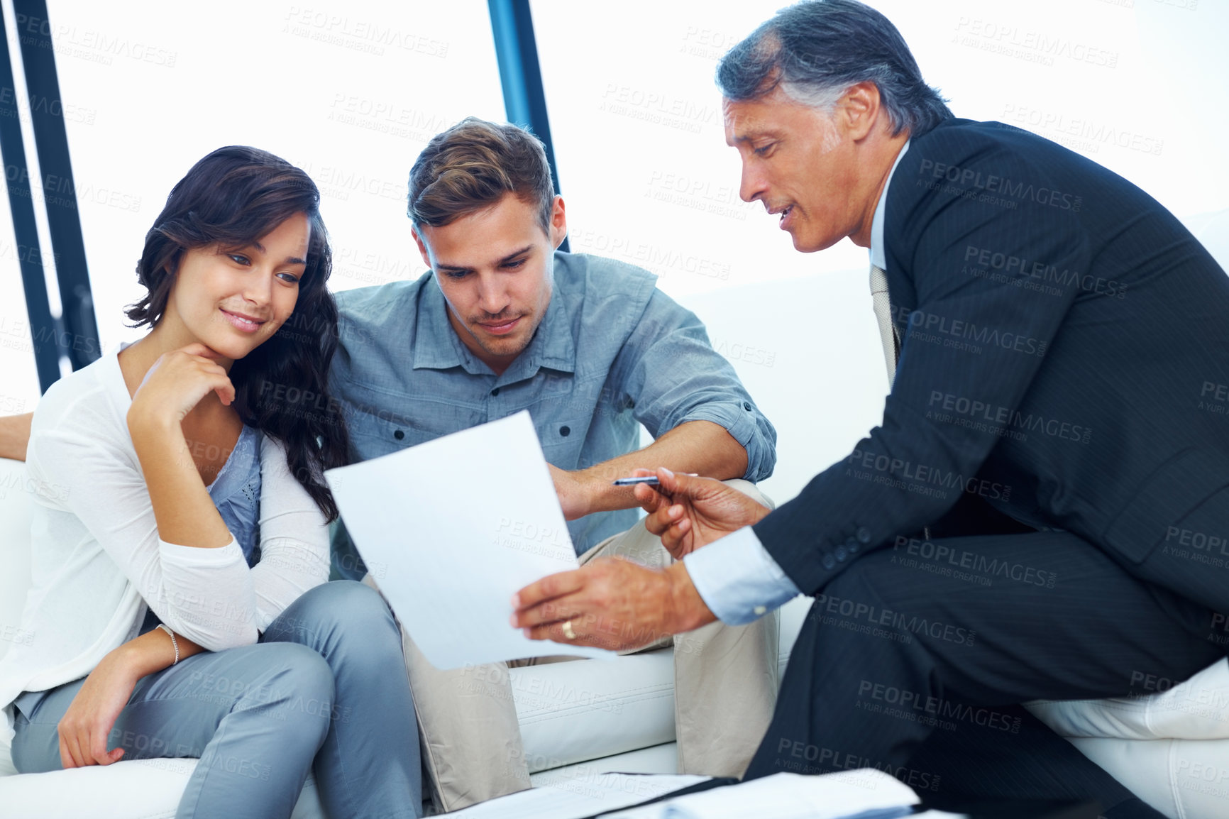 Buy stock photo Mature financial advisor explaining financial plan to young couple at home