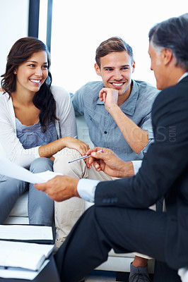 Buy stock photo Mature advisor explaining financial plan to couple at home