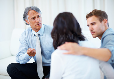 Buy stock photo Confident financial planner having discussion with young couple at home
