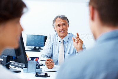 Buy stock photo Mature financial planner discussing plan with clients in office